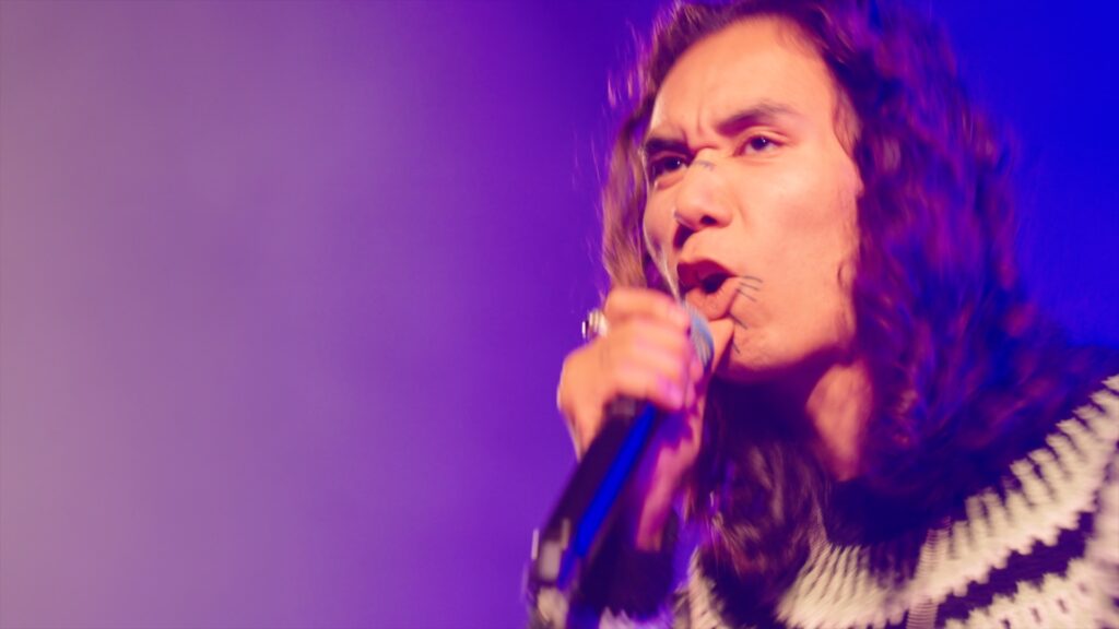 Sanger med mikrofon i lilla scenelys på Kulturmødet 2026